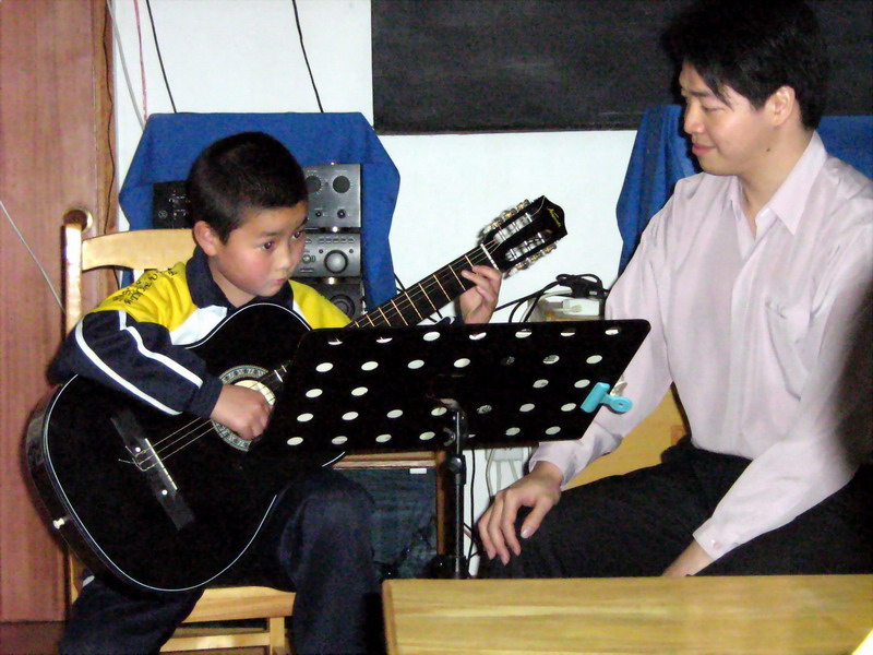 倪老师在教学九岁的音乐学社小学生陈鸿杰小朋友