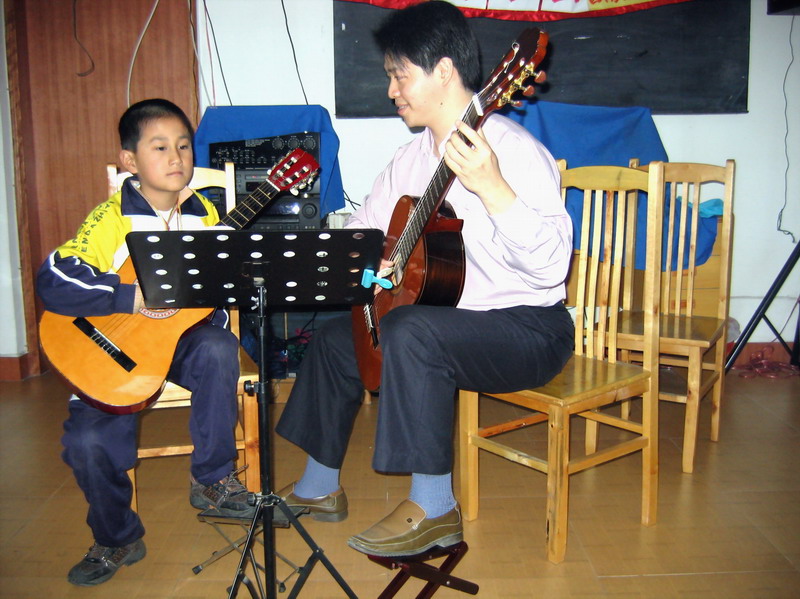 倪老师在教学八岁的音乐学社小学生郑仝小朋友