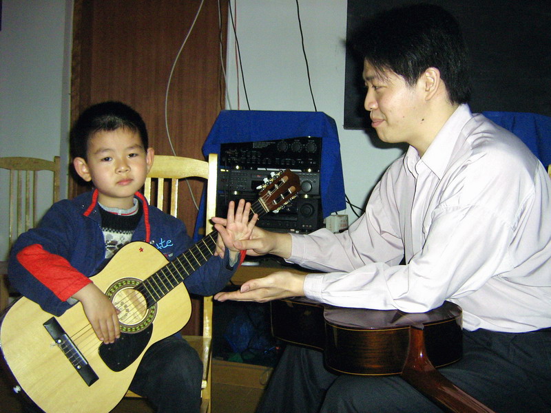 倪老师在教学音乐学社的六岁小学生王云飞小朋友